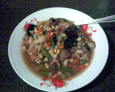 Говяжий суп с фасолью овощами и черносливом в керамической посуде