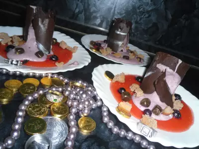 Десерт из черничного мусса с бисквитной крошкой и шоколадом сокровища черной башни