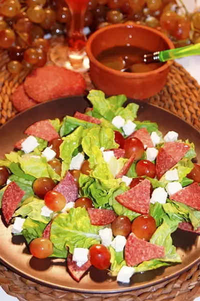 Зелёный салат с виноградом, сыром фета, салями и мятным соусом винегрет..