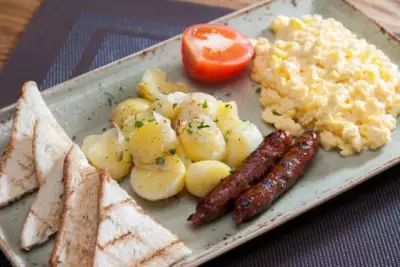Американский завтрак из сосисок картофеля и омлета